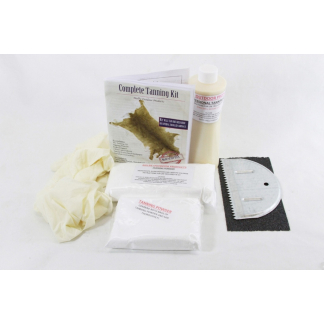 Complete tanning kit with powder, lotion, powder packets, gloves, a tanning guide, and a curved application tool on a white surface.