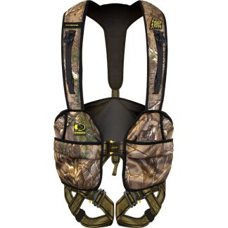 Camouflage hunting safety harness with padded back and multiple straps for securing a hunter in a tree stand.