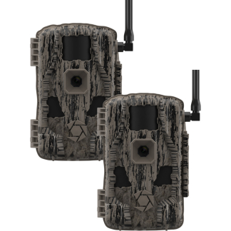Two camouflage trail cameras with external antennas, shown side by side for wildlife monitoring; rugged bark-like pattern and lens housings visible.