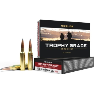 Nosler Trophy Grade ammunition boxes with three brass bullets resting beside them, set against a white background.