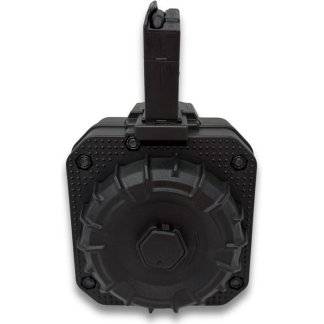 Black drum-style rifle magazine with a top-feed mechanism, viewed from above