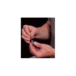 Hands holding a small black cylindrical object with metal ends between fingers, shown against a dark background; highlights the component being demonstrated.