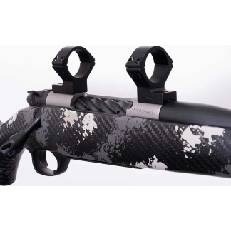 Close-up of a camouflaged rifle with two mounted scope rings on the top rail.